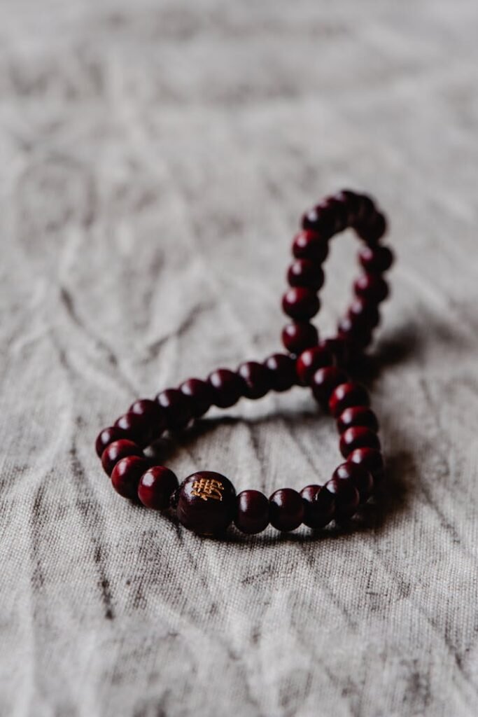 Close-up of a spiritual wooden bead bracelet symbolizing faith on a textured surface.